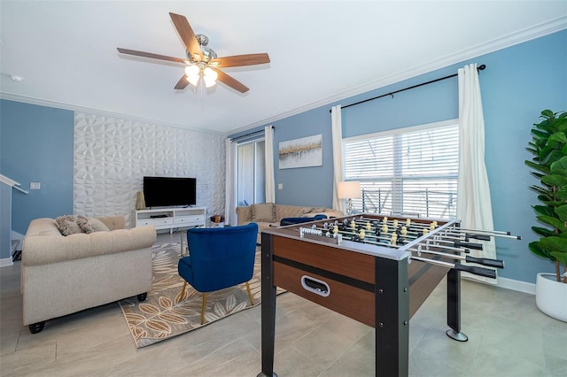 playroom with ceiling fan, ornamental molding, and light tile patterned floors