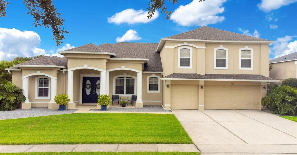 mediterranean / spanish-style house with a porch, a garage, and a front lawn