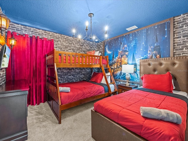 carpeted bedroom featuring a textured ceiling, a notable chandelier, and brick wall