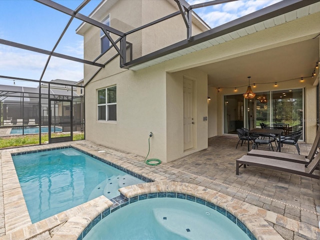 view of swimming pool with glass enclosure, an in ground hot tub, and a patio