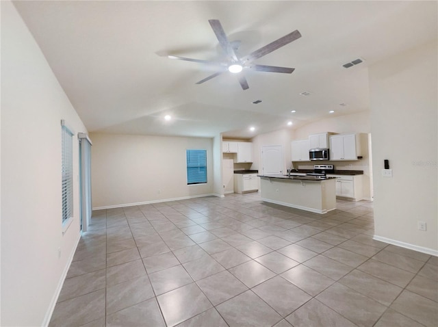 unfurnished living room with ceiling fan, light tile patterned floors, and vaulted ceiling