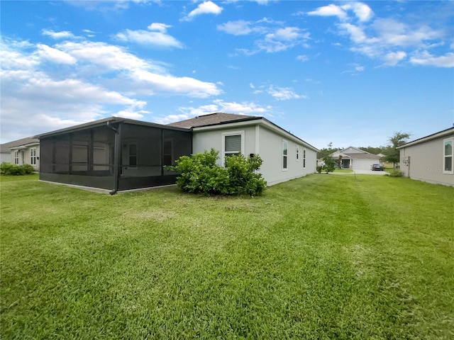 back of property featuring a sunroom and a yard