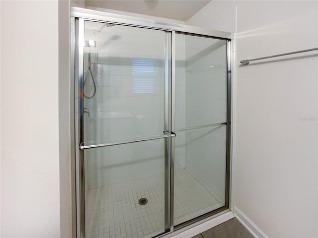 bathroom with tile patterned floors and a shower with door