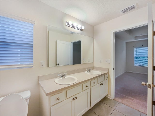 bathroom featuring tile patterned floors, vanity, toilet, and a textured ceiling