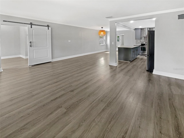 living room with a barn door and dark wood-type flooring