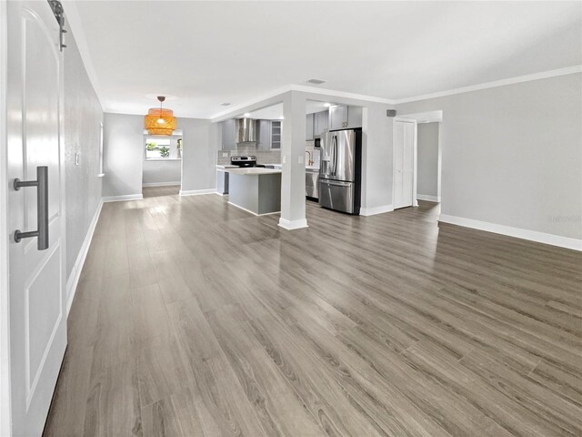 unfurnished living room with crown molding and hardwood / wood-style flooring