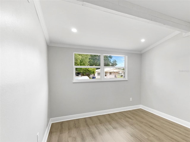 spare room featuring hardwood / wood-style floors and crown molding