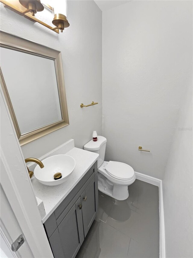 bathroom featuring tile patterned floors, vanity, and toilet