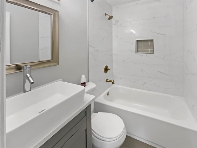 full bathroom featuring vanity, tiled shower / bath combo, and toilet