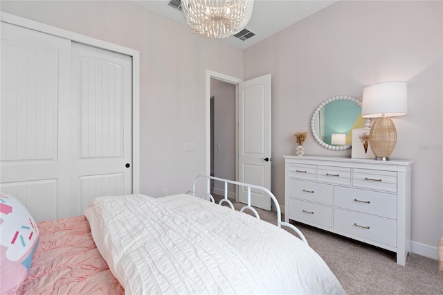 bedroom featuring an inviting chandelier, carpet floors, and a closet