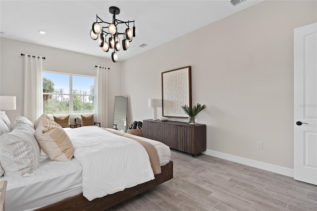 bedroom featuring light hardwood / wood-style floors and an inviting chandelier