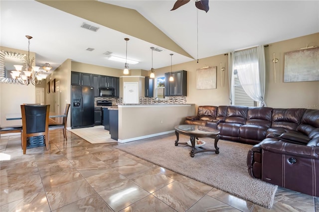 living room featuring lofted ceiling and ceiling fan with notable chandelier