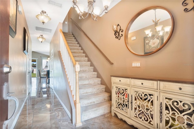 staircase with a notable chandelier