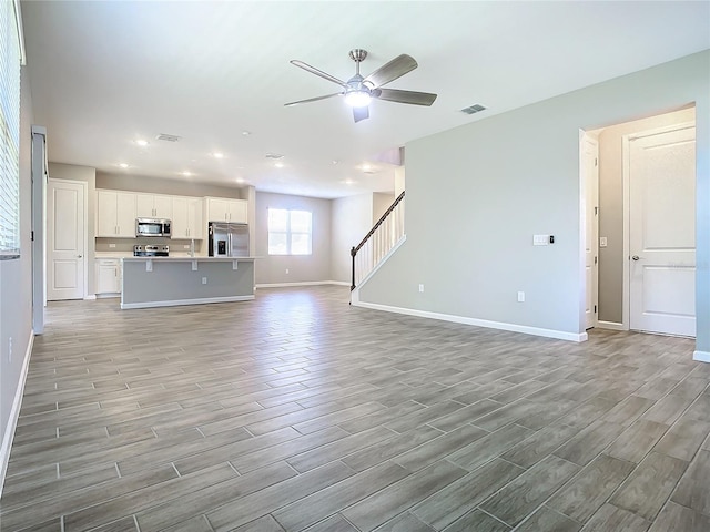 unfurnished living room with ceiling fan