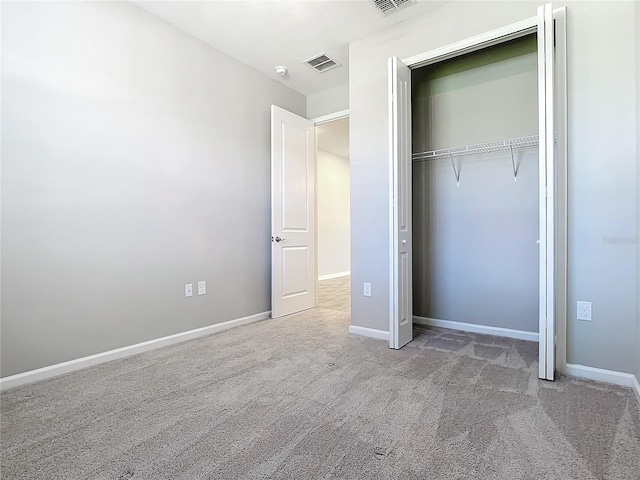 unfurnished bedroom featuring light carpet and a closet