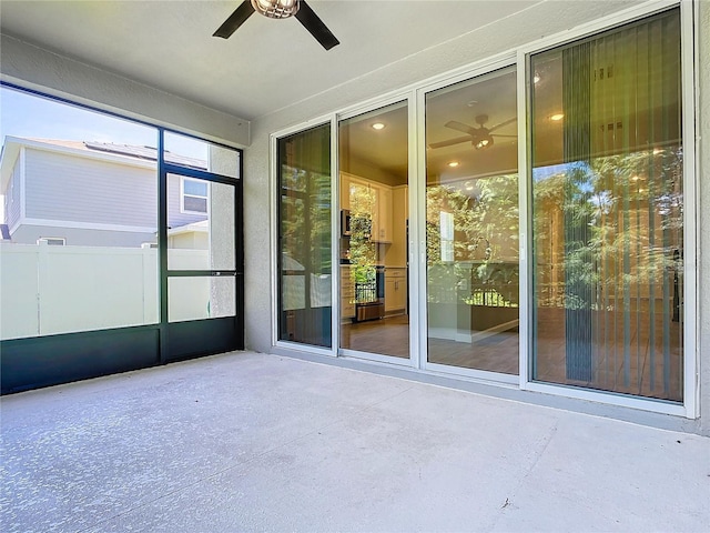 unfurnished sunroom with ceiling fan