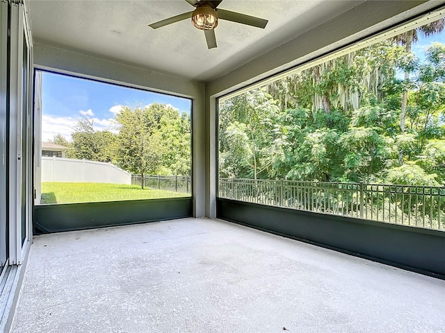 unfurnished sunroom featuring ceiling fan