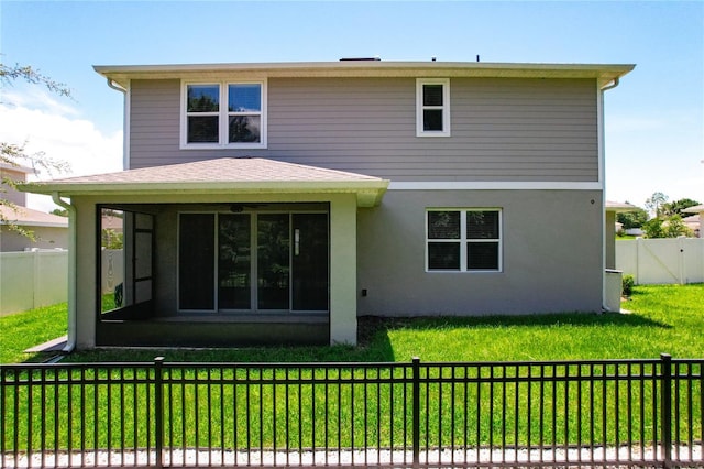 back of property featuring a sunroom and a lawn