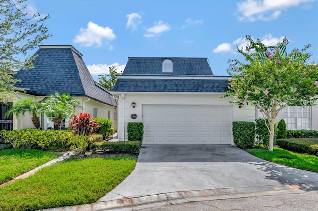 view of front facade with an attached garage, a shingled roof, mansard roof, and concrete driveway