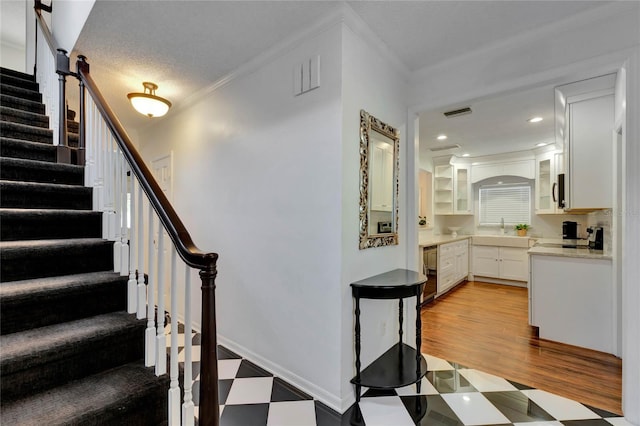 stairs featuring baseboards, visible vents, ornamental molding, tile patterned floors, and recessed lighting