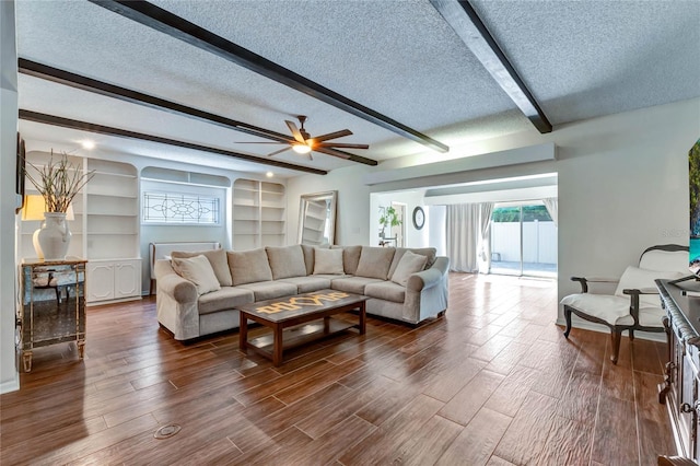 living area featuring a wealth of natural light, dark wood-type flooring, and a textured ceiling