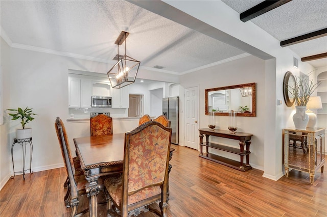 dining area with light wood finished floors, visible vents, a textured ceiling, a chandelier, and beamed ceiling