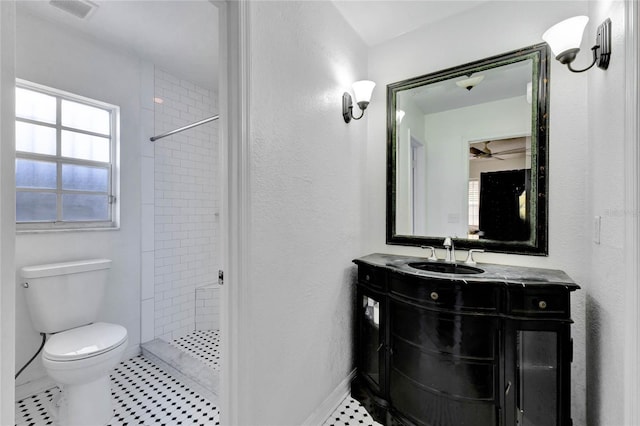 bathroom with toilet, vanity, visible vents, baseboards, and a shower stall