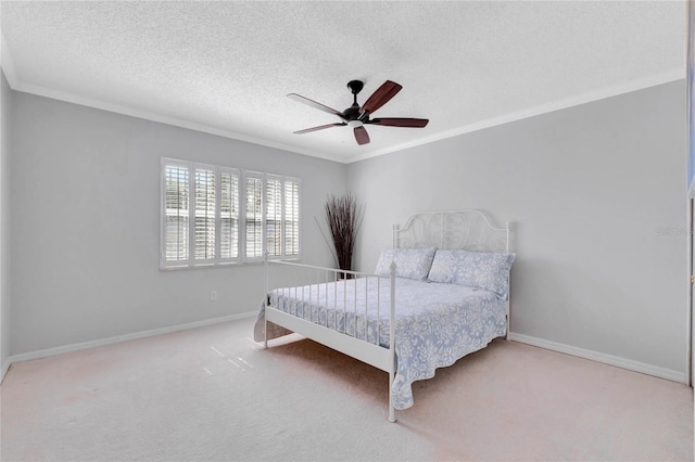 bedroom featuring light carpet, baseboards, a ceiling fan, ornamental molding, and a textured ceiling