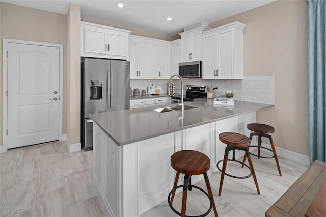 kitchen featuring white cabinets, sink, kitchen peninsula, and stainless steel appliances