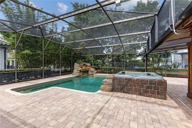 view of swimming pool with glass enclosure, an in ground hot tub, and a patio