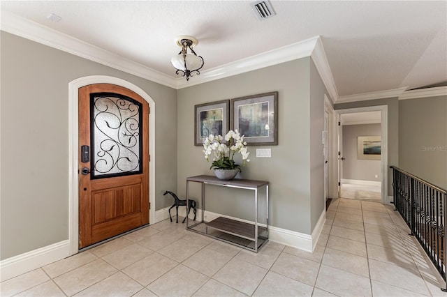 tiled entrance foyer with a textured ceiling and ornamental molding