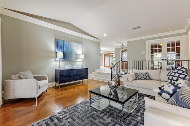 living room with vaulted ceiling, crown molding, hardwood / wood-style flooring, and french doors