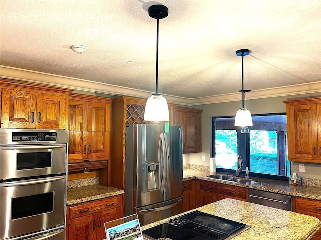 kitchen featuring appliances with stainless steel finishes, decorative light fixtures, sink, ornamental molding, and light stone counters