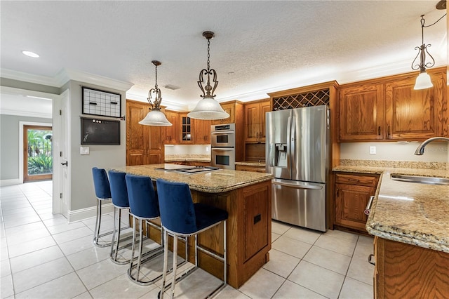 kitchen featuring appliances with stainless steel finishes, sink, hanging light fixtures, and a center island