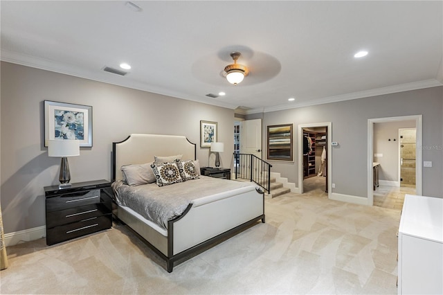 bedroom featuring ceiling fan, crown molding, a spacious closet, light carpet, and a closet