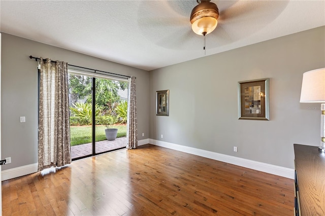 empty room featuring a textured ceiling, ceiling fan, and hardwood / wood-style floors