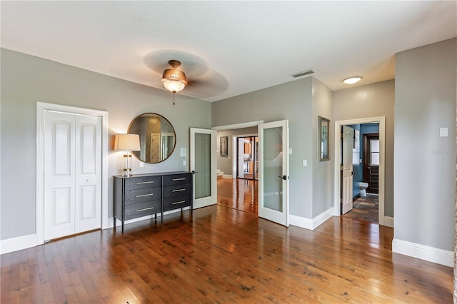 unfurnished bedroom featuring ceiling fan and dark wood-type flooring