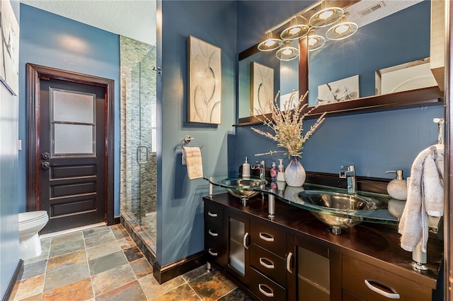 bathroom featuring toilet, walk in shower, and vanity