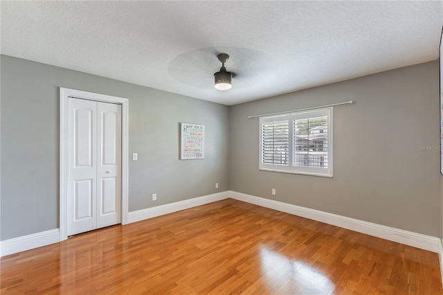 unfurnished room featuring a textured ceiling, ceiling fan, and hardwood / wood-style flooring