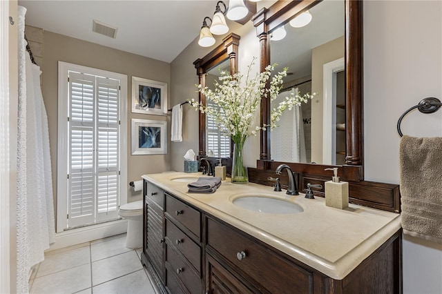 bathroom featuring toilet, a healthy amount of sunlight, tile patterned floors, and vanity