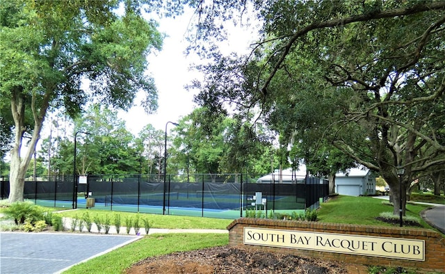 view of sport court featuring a lawn