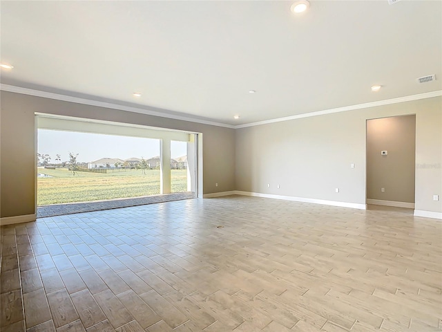 empty room featuring ornamental molding and light hardwood / wood-style floors