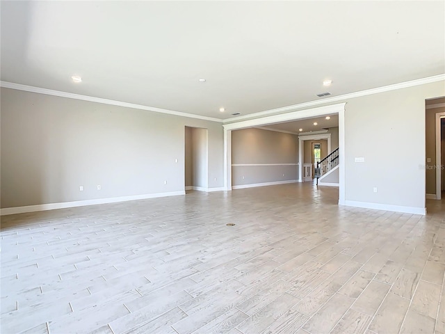 spare room featuring ornamental molding and light hardwood / wood-style floors