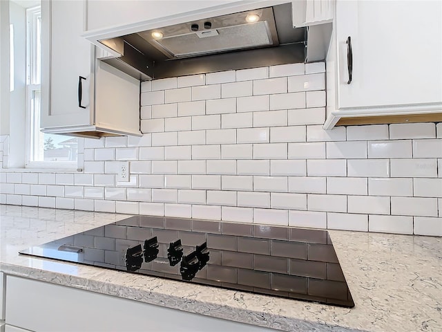 kitchen with white cabinetry, light stone counters, and custom exhaust hood