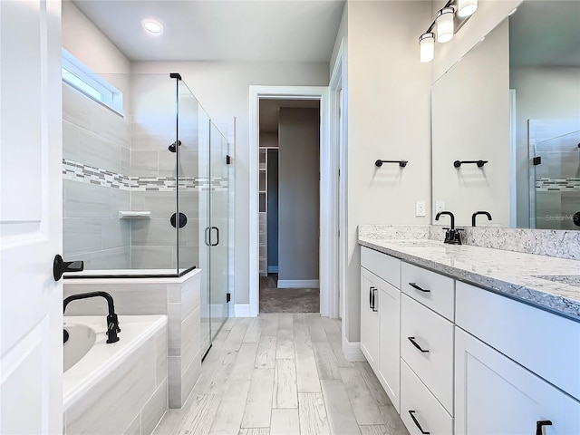 bathroom featuring plus walk in shower, wood-type flooring, and vanity