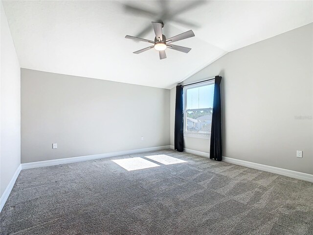 empty room featuring ceiling fan, lofted ceiling, and light carpet