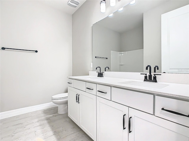 bathroom with vanity, wood-type flooring, a shower, and toilet