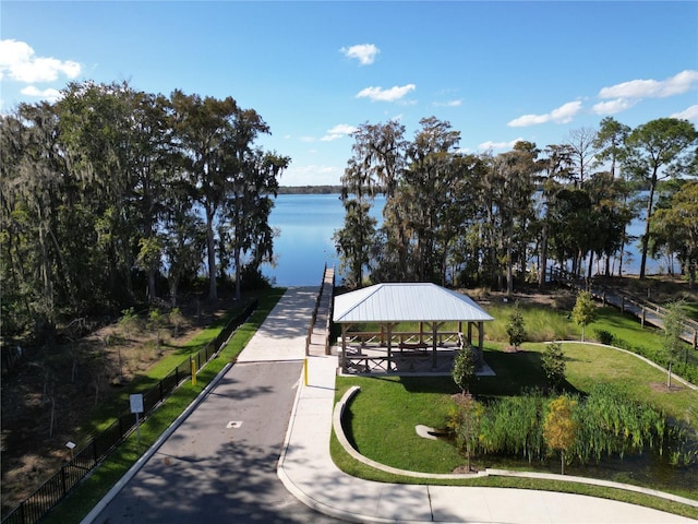 view of community with a gazebo, a water view, and a yard