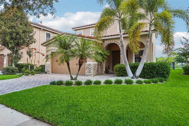 mediterranean / spanish home featuring a garage and a front yard