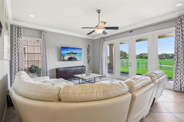 living room featuring light tile patterned flooring, a healthy amount of sunlight, and ornamental molding